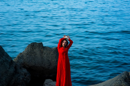 shallow focus photography of a woman standing on stone while raising her hands on her head in Batumi Georgia