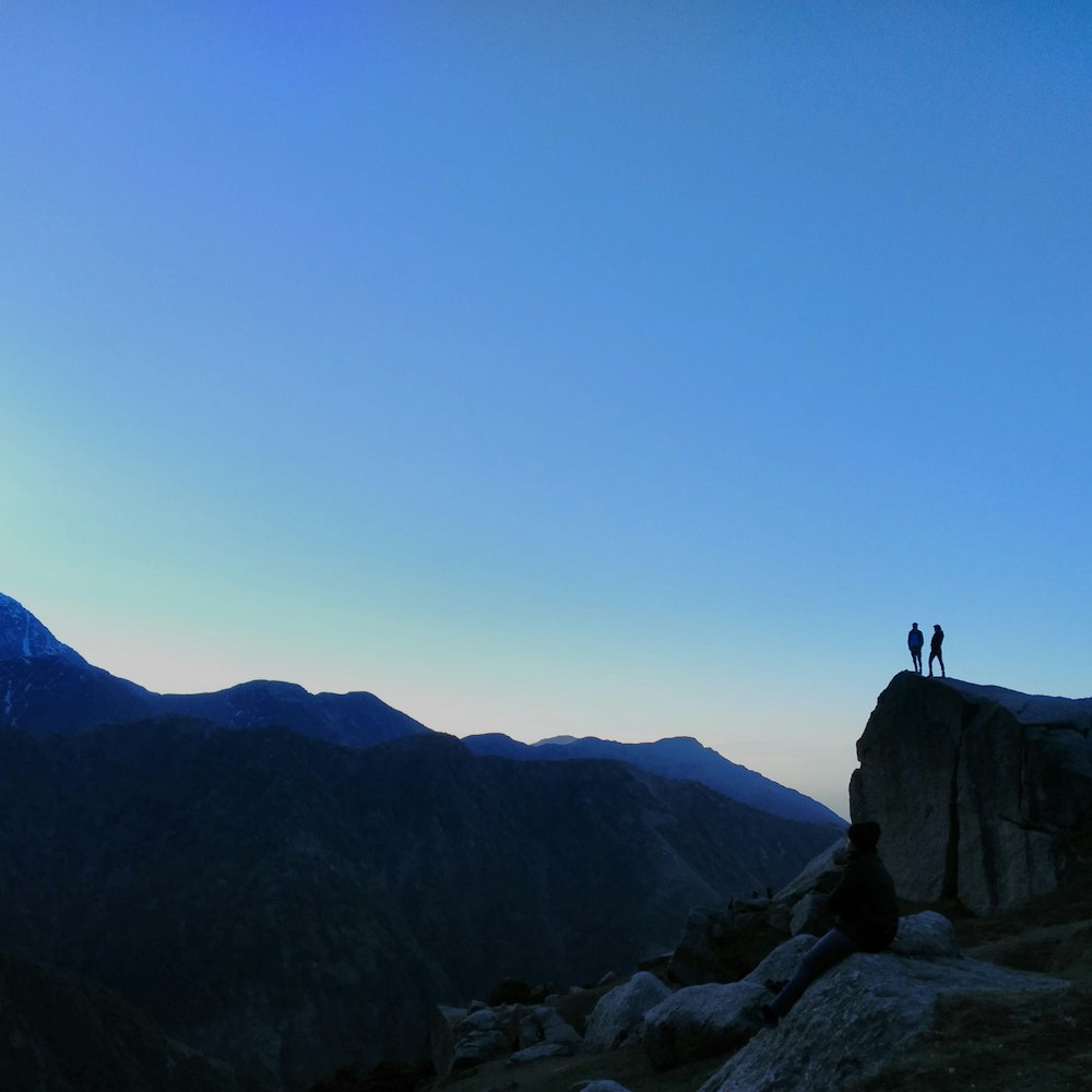 man and woman standing on mountain edge