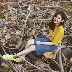 A smiling young woman confidently leading a youth workshop outdoors.