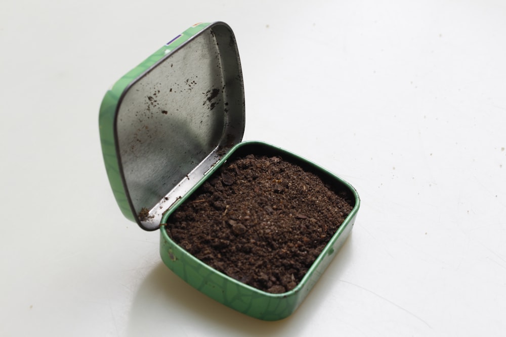brown soil in green metal box