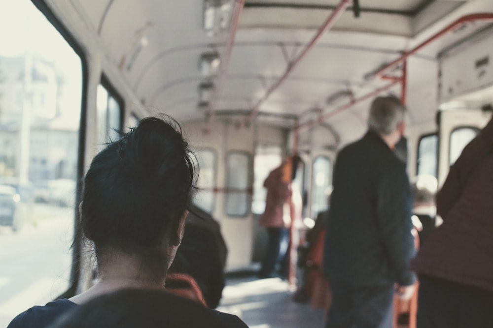 persone che si siedono e si levano in piedi in treno