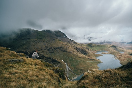 man sitting on top of mountain in Snowdon United Kingdom