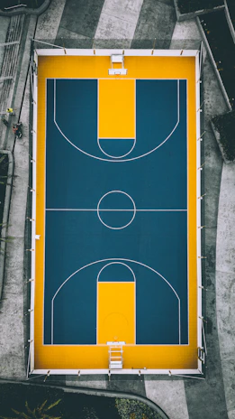 A panoramic view of a newly built, high-end basketball court with sleek design and clear markings.