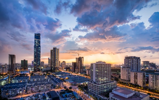 gray high-rise buildings under gray clouds during golden hour in Hanoi Vietnam
