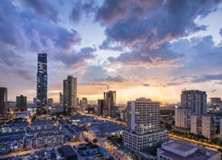 gray high-rise buildings under gray clouds during golden hour