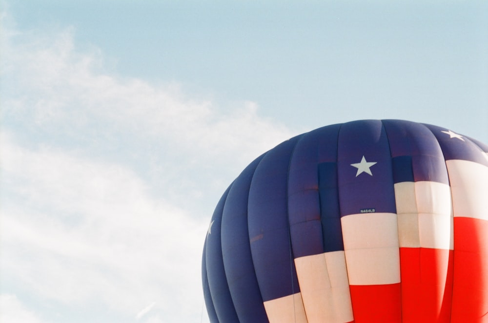 Foto do balão de ar azul, branco e vermelho durante o dia