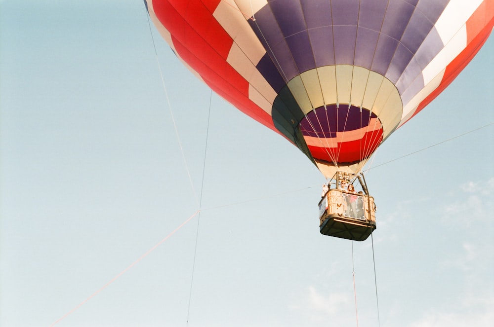 Foto de globo aerostático volando bajo un cielo azul claro