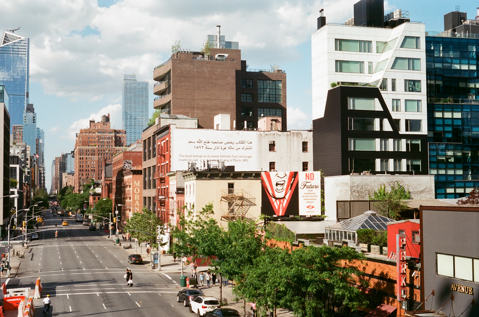 Travel photograph: A west-side Manhattan street, murals and mixed old and new buildings seen from the elevated High Line.