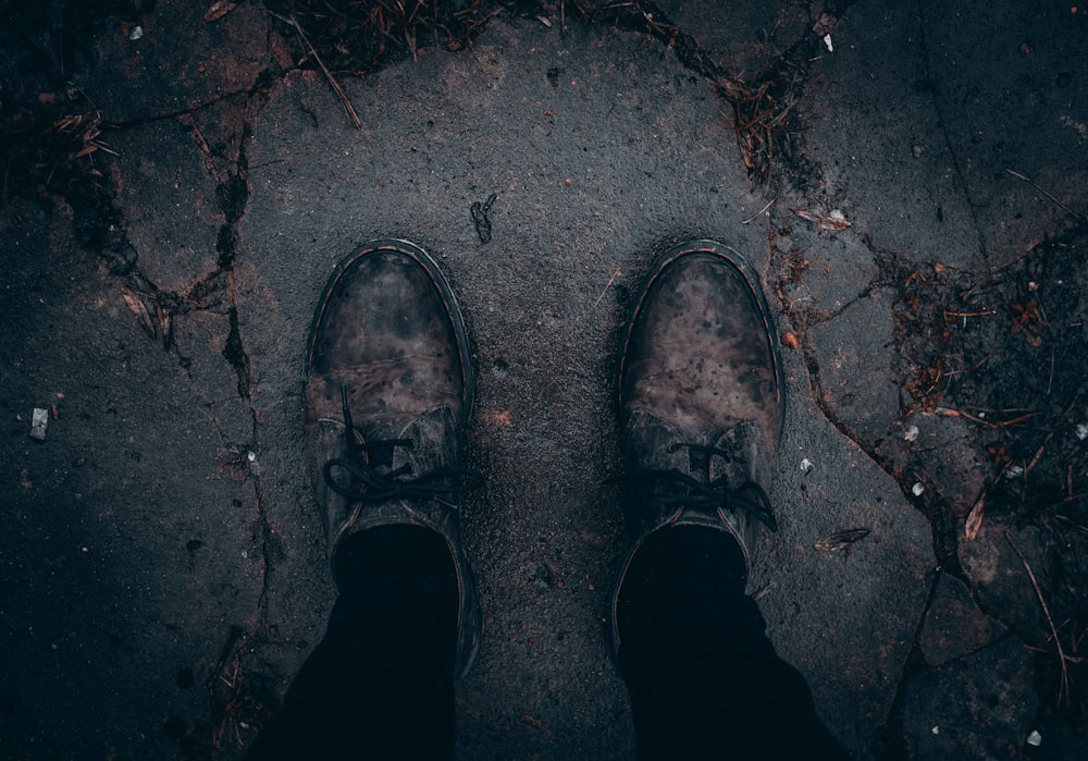 person taking photo of pair of brown shoes