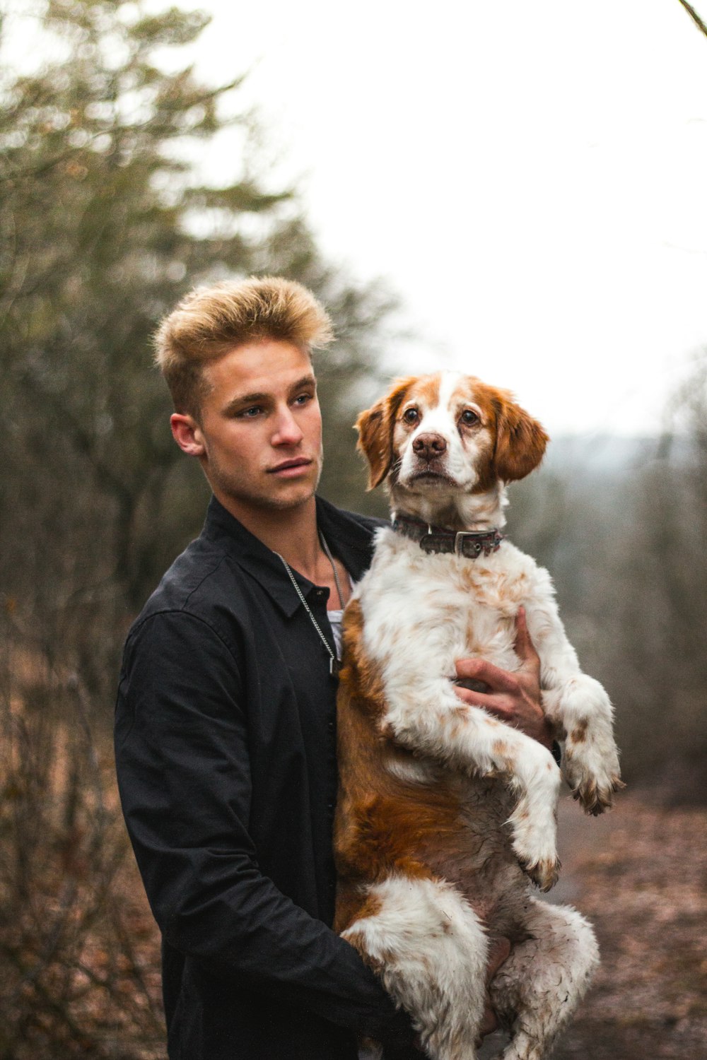 man carrying dog on woods