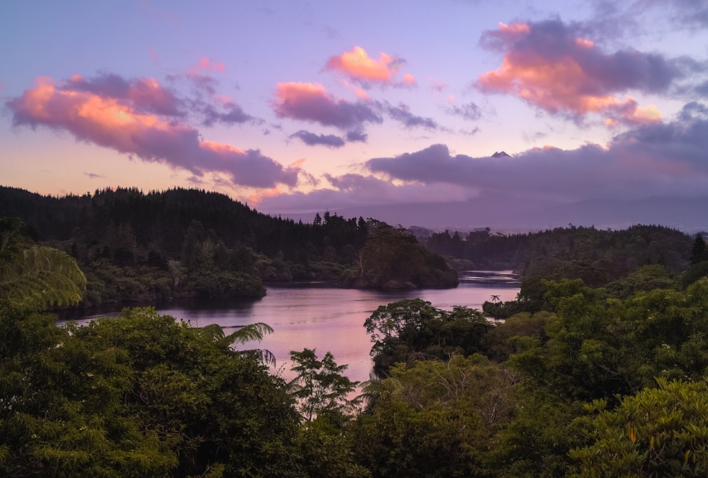 body of water surrounded by green islands under cloudy sky