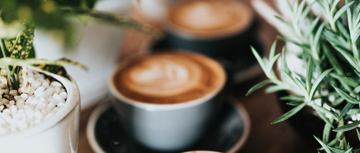 shallow focus photography of coffee late in mug on table