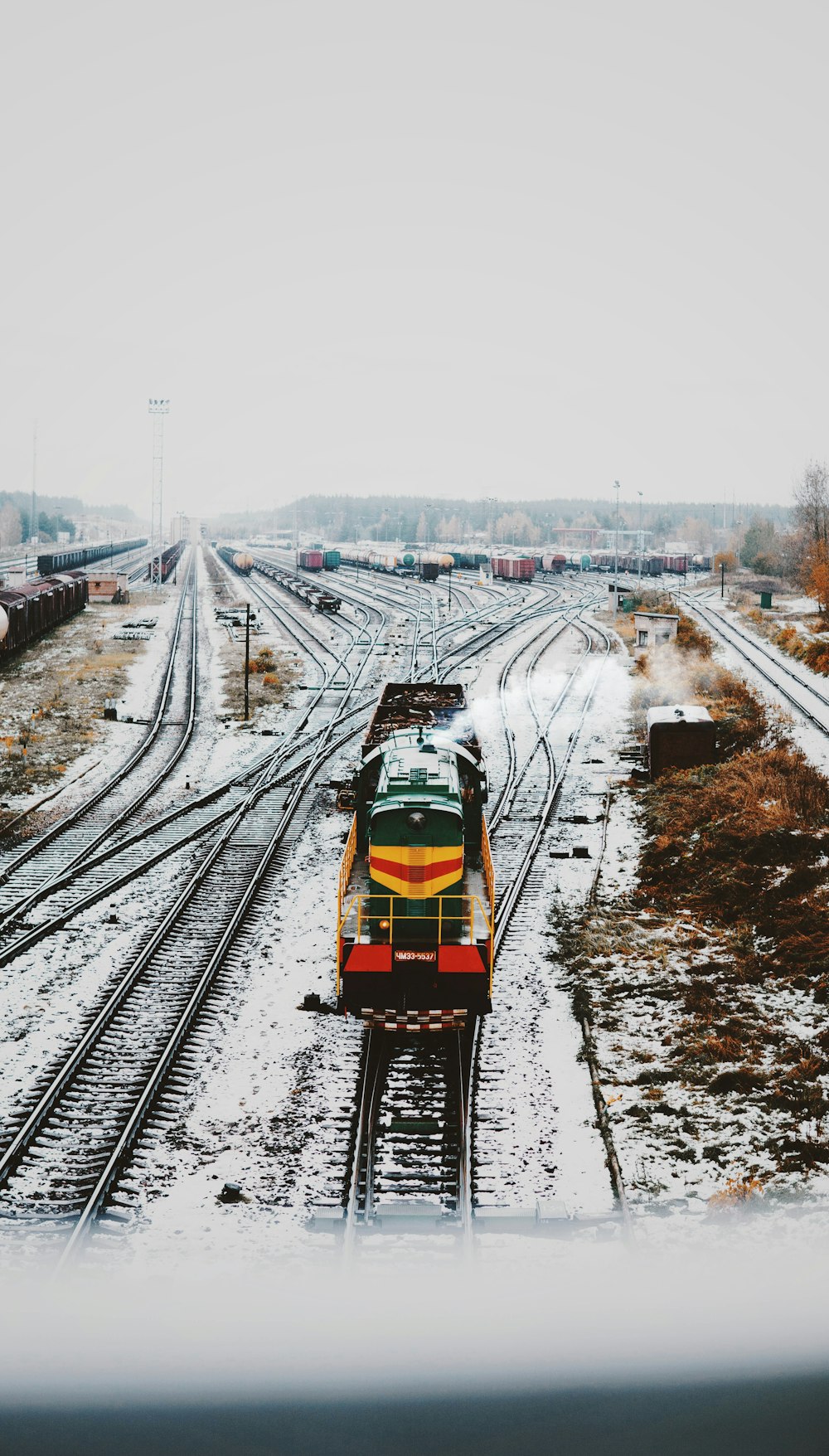 Tren locomotora amarillo y verde en movimiento en ferrocarriles ferroviarios