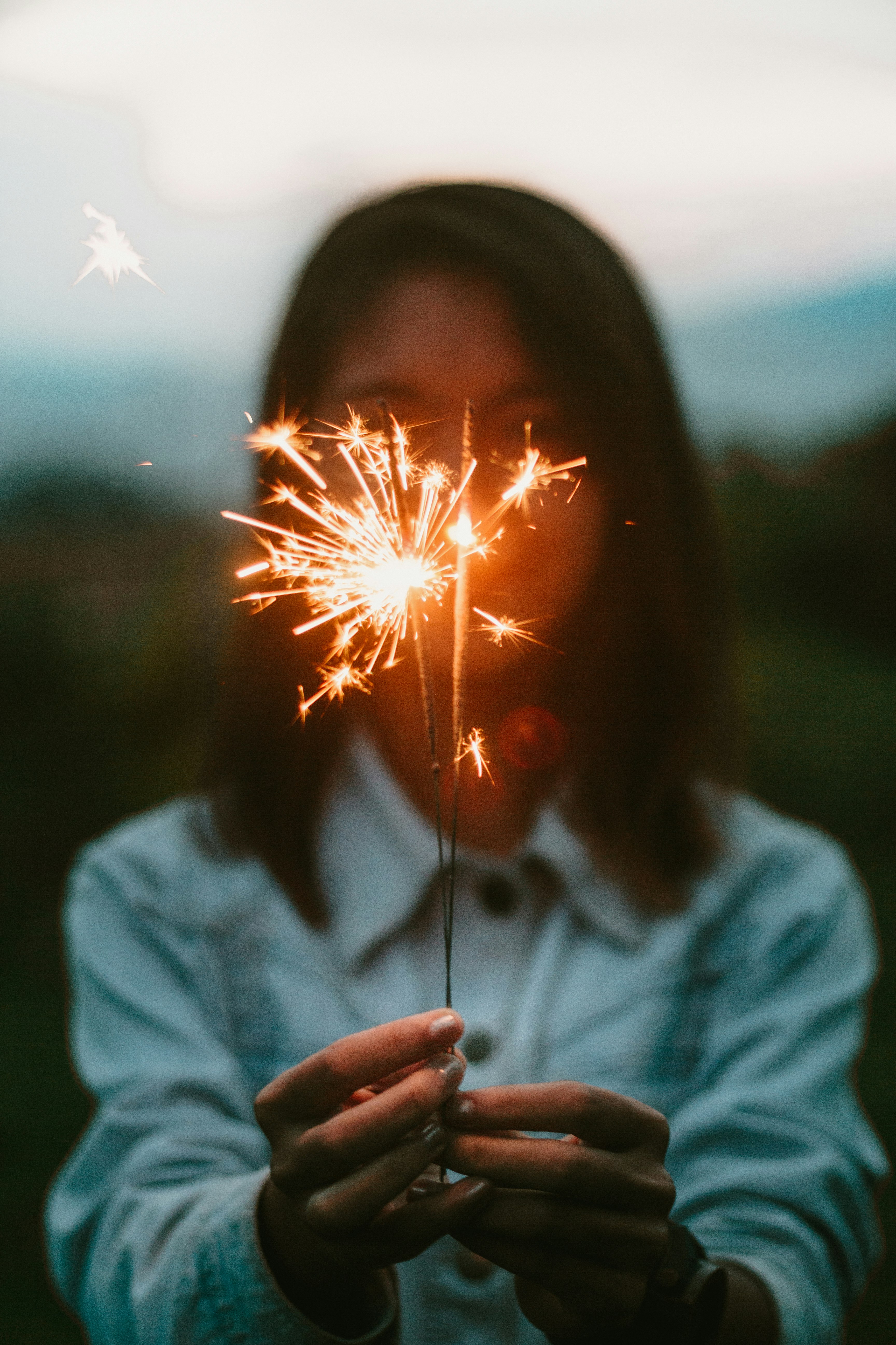 woman holding lighted sparklers