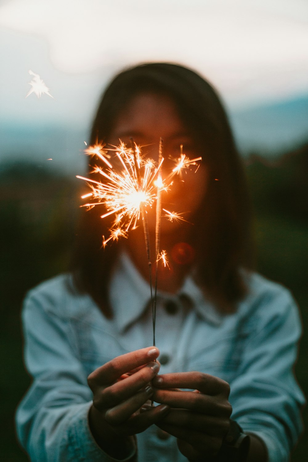 woman holding lighted sparklers