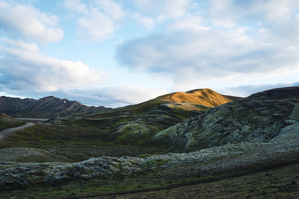 green mountains under cloudy sky