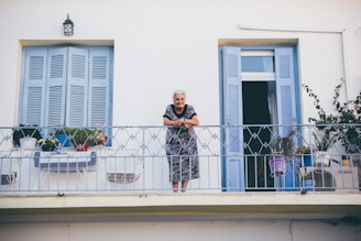 Elderly person comfortably enjoying fresh air on a balcony secured with safety nets.