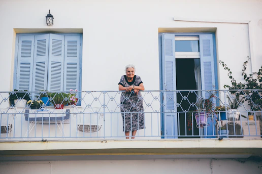 An elderly person enjoying a balcony safely enclosed by a well-installed net.