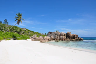 Pristine white sandy beach with crystal clear turquoise waters and a small luxury resort in NTB.
