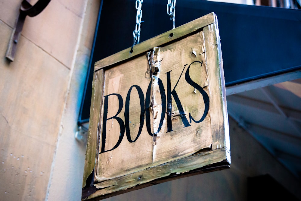 Signalétique de livre accrochée à côté d’un mur blanc