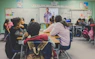 students in classroom with teacher presenting