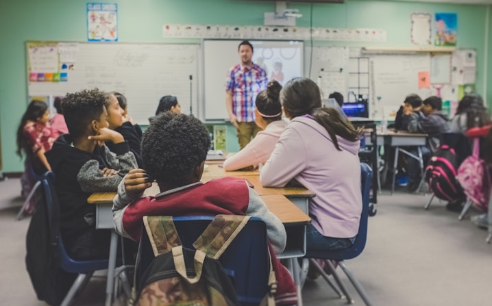 A teacher addressing students in a classroom, illustrating the interactive and diverse learning 