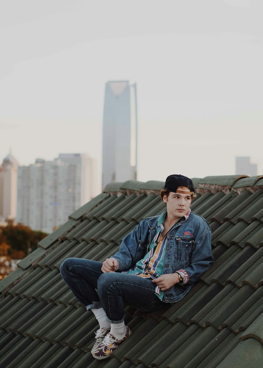 man wearing jacket and sitting on the roof