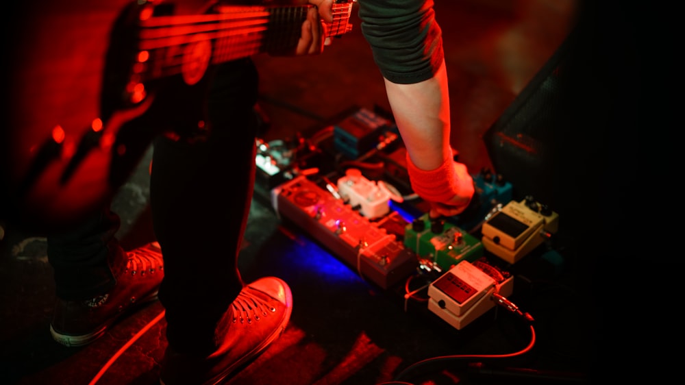 chitarrista che regola gli effetti della chitarra