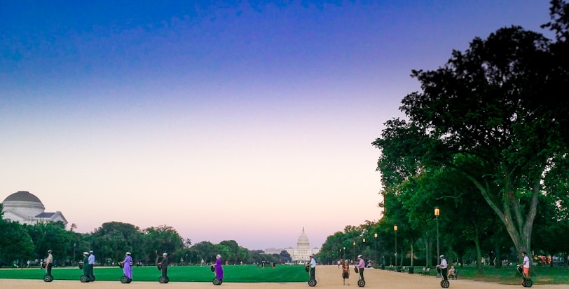 Group of friends enjoying a ride on heiwa electric vehicles in a sunny park.