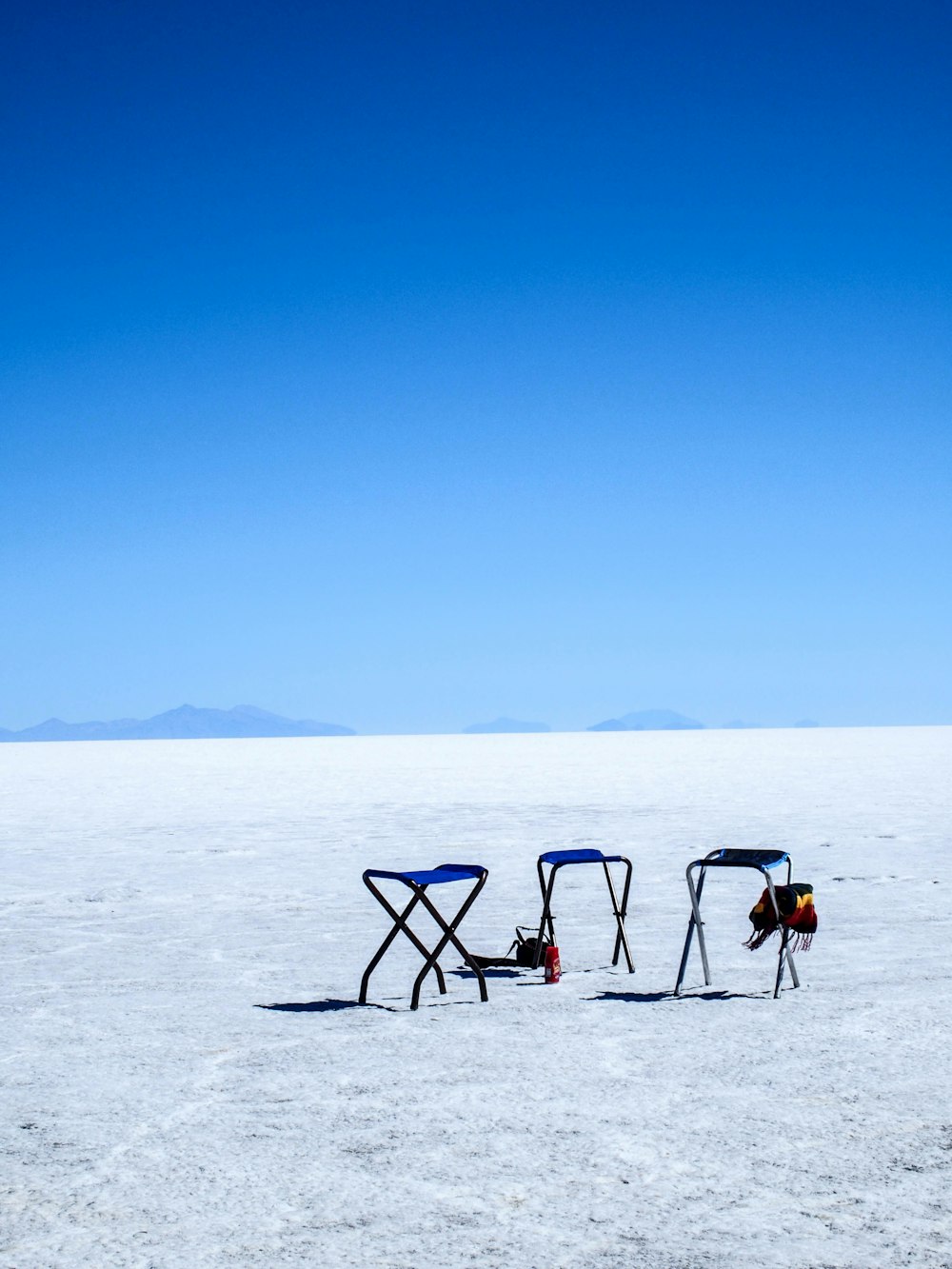 Tre sedie da campeggio pieghevoli blu e grigie a terra