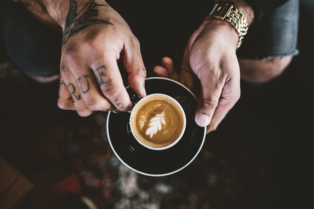 person holding double-compound leaf coffee art