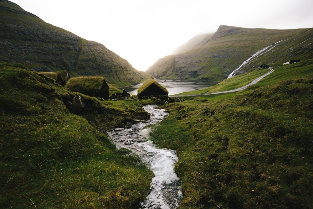 water stream near green hills