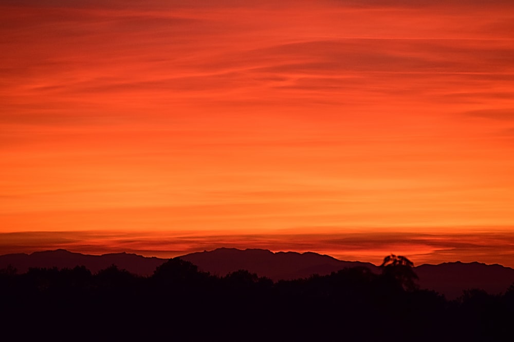 silhueta da montanha sob o céu alaranjado