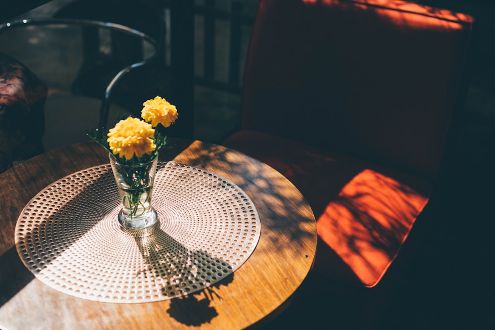 yellow cluster petaled flower on clear glass vase