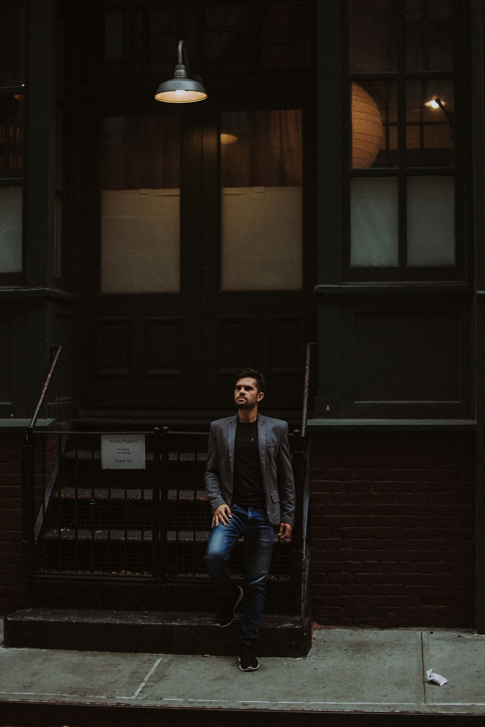 man leaning on black metal gate