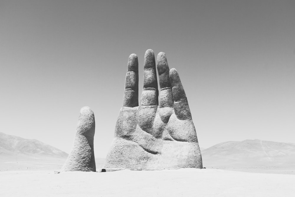 grayscale photography of hand sculpture on sad