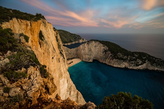 brown rocky mountains next to body of water in Shipwreck Beach Greece