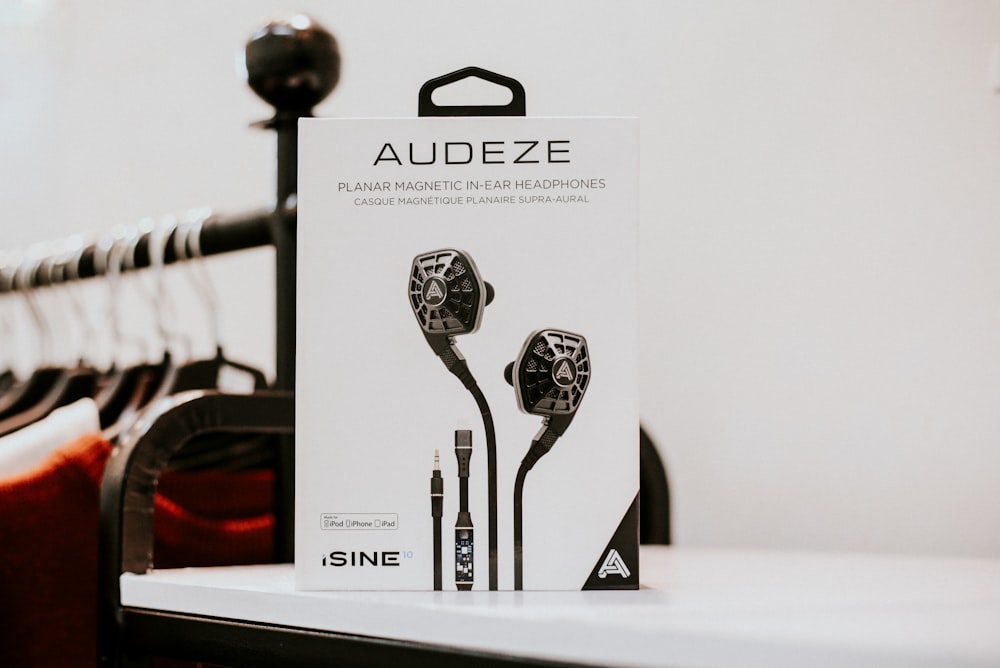 black Audeze earphones box on white wooden surface