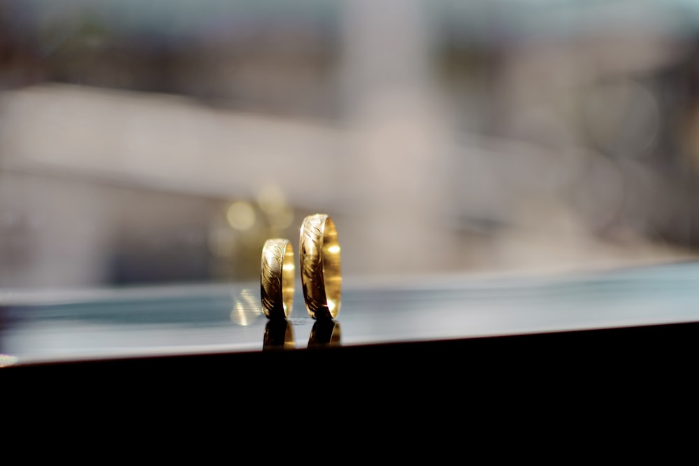 Fotografía de enfoque superficial de anillos de pareja de color dorado