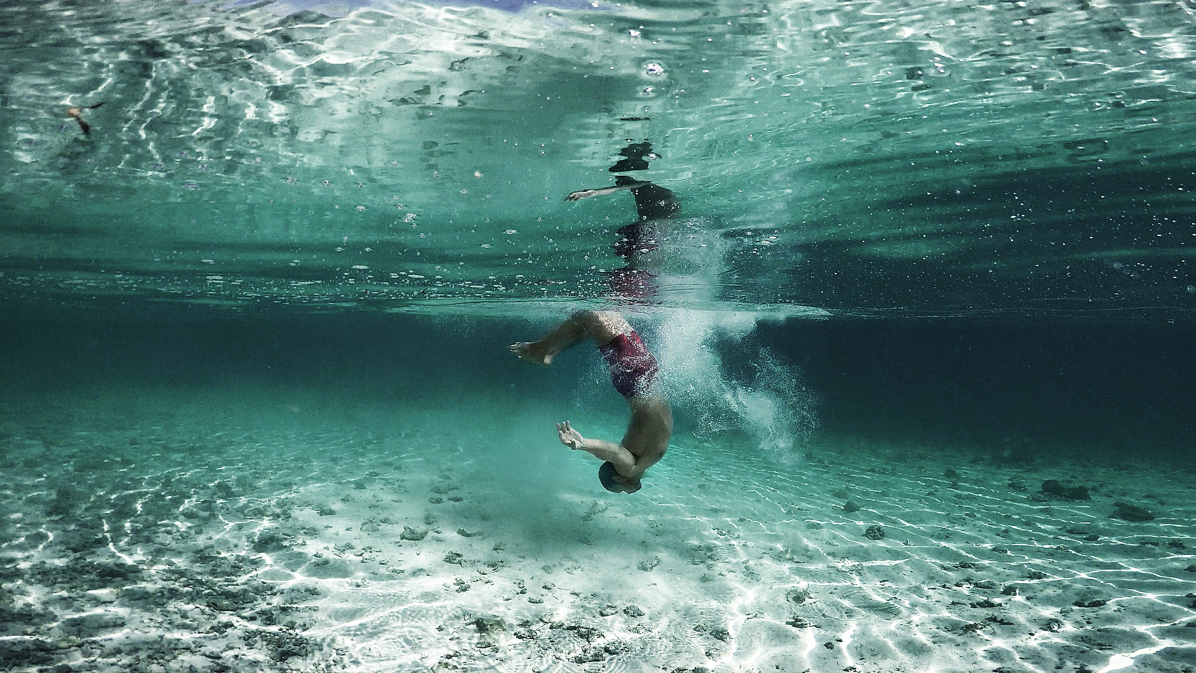 person wearing red shorts underwater