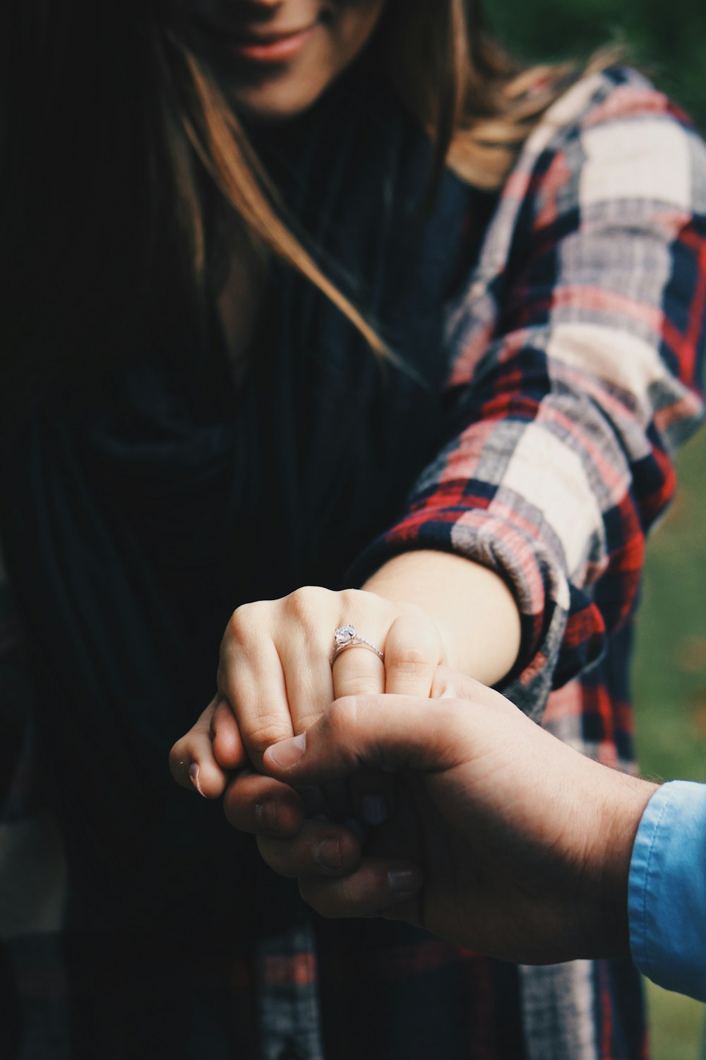 woman holding hands showing her ring