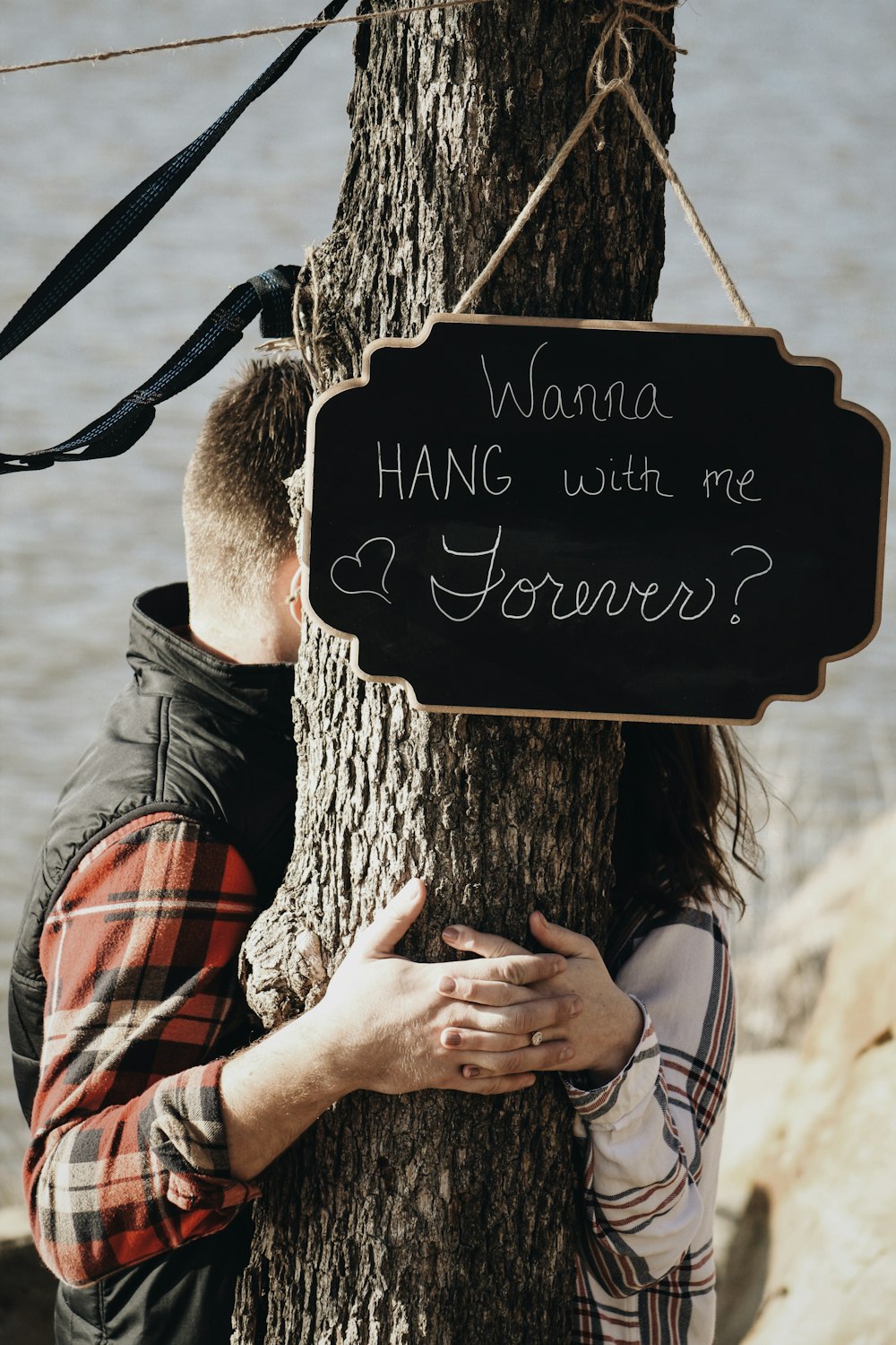 couple standing behind a tree