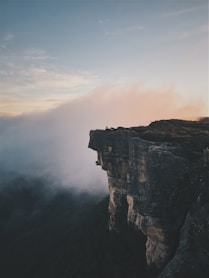 person sitting on mountain cliff