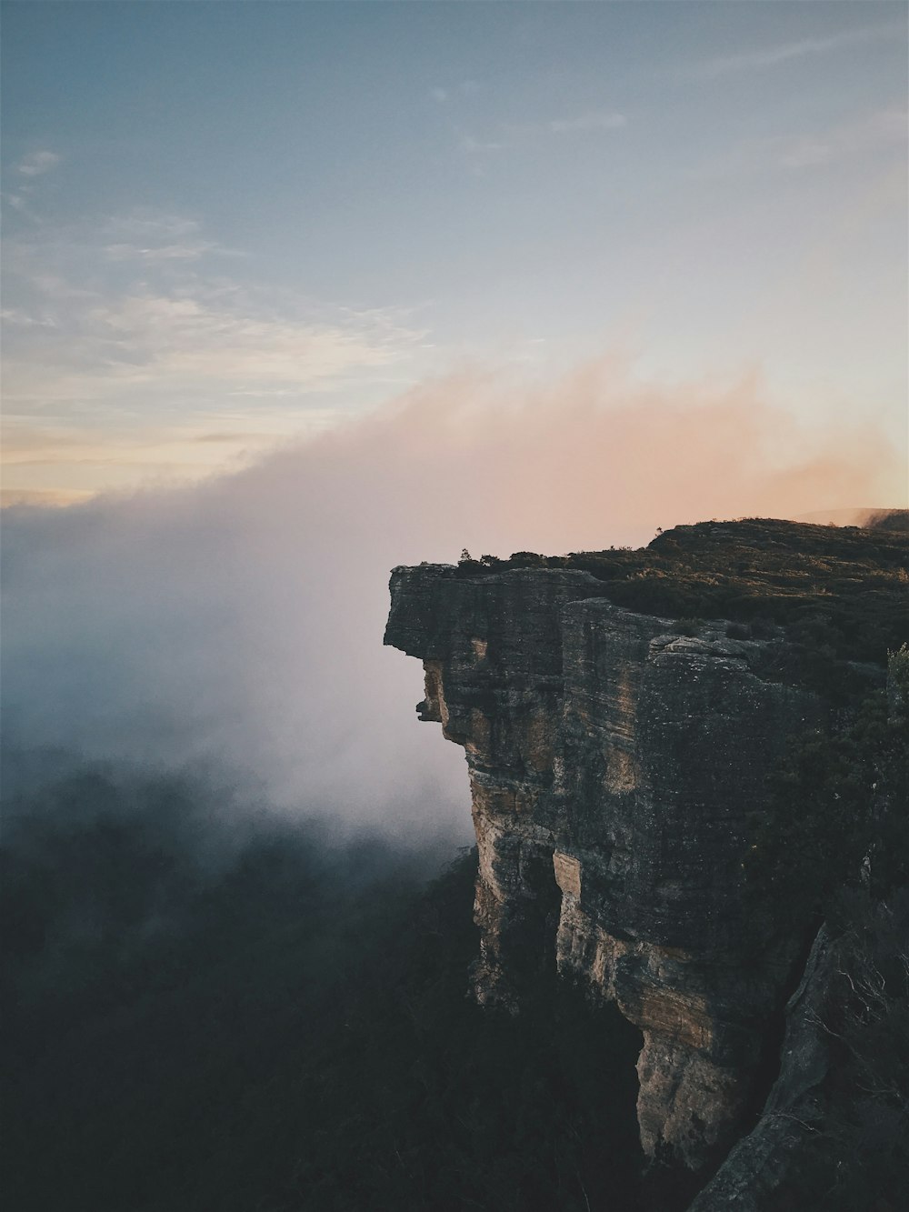 person sitting on mountain cliff