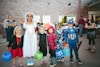 children standing while holding Jack 'o lantern and wearing costume
