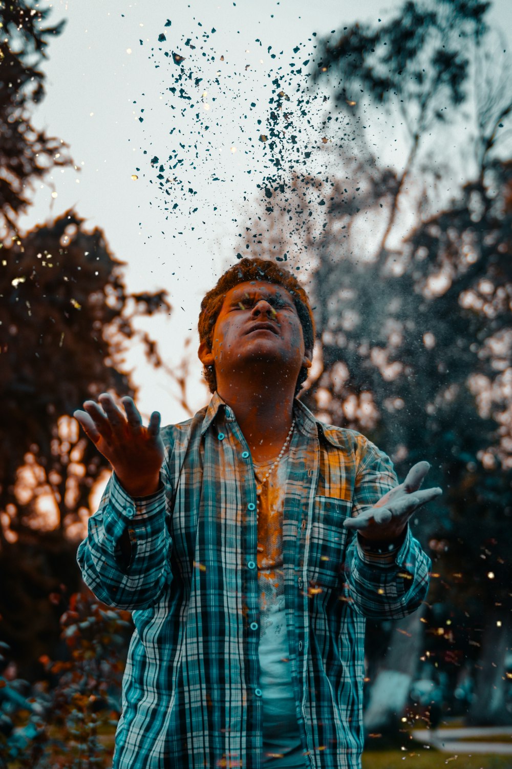 man looking up while raising his both hands