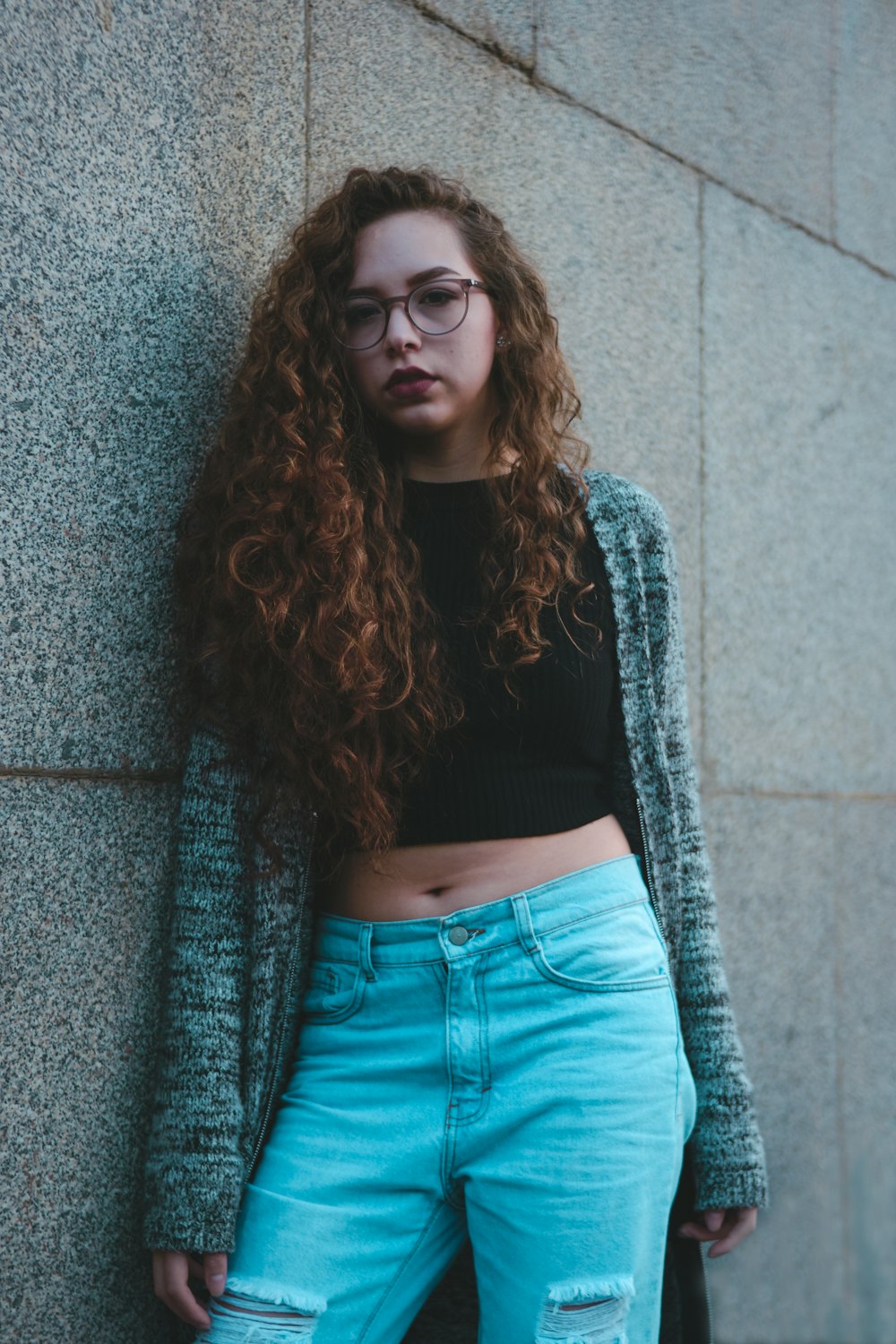 woman leaning on gray wall tiles