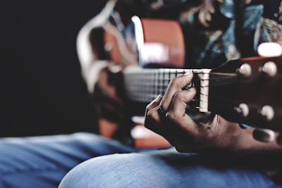 Close-up of a musician's hand playing guitar strings with a subtle overlay of digital code representing copyright protection.