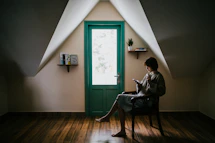 woman sitting on a chair inside white painted room