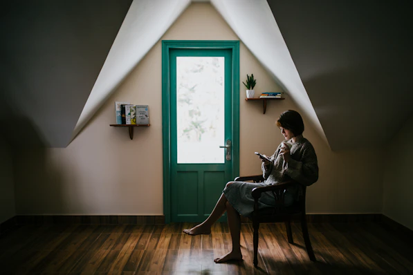 woman sitting on a chair inside white painted room